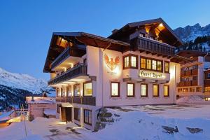 上陶恩Hotel Garni Haus Tyrol的山间酒店,地面下雪