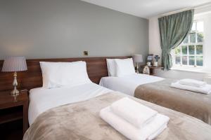 大艾顿The King's Head Inn - The Inn Collection Group的一间卧室配有两张床和白色毛巾。