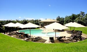 塔勒克马拉营酒店的一个带椅子和遮阳伞的游泳池
