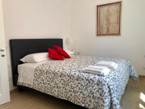 博洛尼亚Temporary House de' Giudei的一间卧室配有一张带红色枕头的床