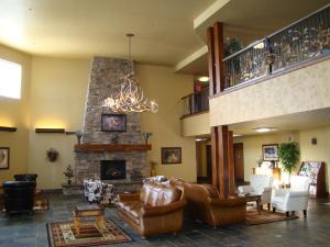 米苏拉石头小溪酒店的客厅配有皮革家具和壁炉