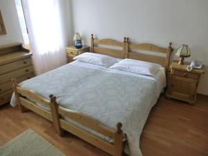 奥伦佐卡多利Ajarnola Locazioni Turist的一间卧室配有木床和2个床头柜