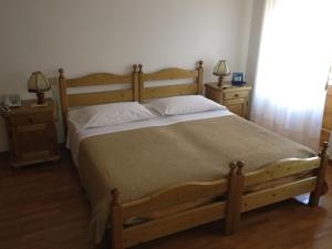 奥伦佐卡多利Ajarnola Locazioni Turist的一间卧室配有一张带2个床头柜的大型木床