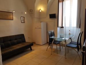 科里利亚诺多特兰托Calì Nitta Storic的带沙发、桌子和冰箱的客厅