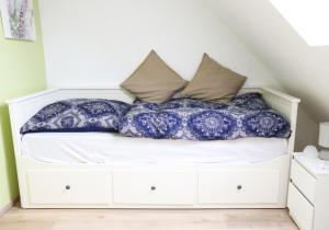 RiesteFerienhaus am Alfsee的一张位于蓝色和白色枕头间的床