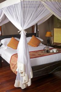 塔勒克马拉营酒店的一间卧室配有一张带天蓬的床