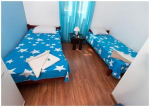 Donje Selo na ŠoltiApartments FRAGOLINA的配有2张位于客房的床铺,配有蓝色的星光床单