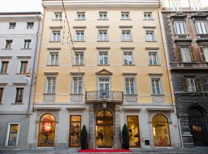 的里雅斯特Hotel Coppe Trieste - Boutique Hotel的一座大型黄色建筑,上面设有阳台