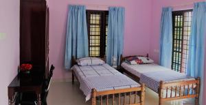 特里凡得琅Puthenchirayil Homestay的配有粉红色墙壁的客房内的两张床