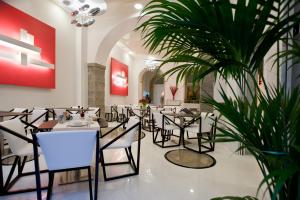 的里雅斯特Hotel Coppe Trieste - Boutique Hotel的一间设有桌椅的餐厅,以及一间种植了植物的餐厅
