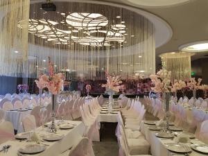 埃尔比勒凡皇家酒店的宴会厅配有白色的桌椅和吊灯