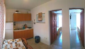 卢卡瓦克Apartman Knezevic的厨房配有桌子,门通往客房