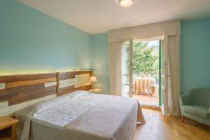 蓬特雷莫利卡德尔摩洛度假酒店的卧室配有床、椅子和窗户。