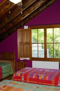 圣克鲁斯德拉塞罗斯圣克鲁斯旅馆的一间卧室设有两张床和紫色的墙壁
