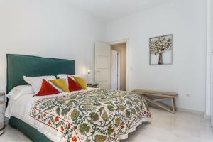 塞维利亚大教堂旁生活公寓的一间卧室配有一张大床,提供红色和黄色枕头