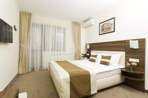比斯特里察Grand Hotel Coroana的一间设有大床和窗户的酒店客房