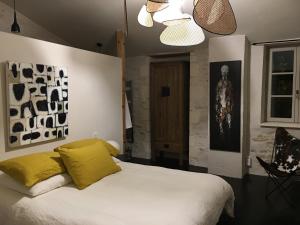 阿尔桑雷Les Clés d'Ars的卧室配有一张带黄色枕头的大型白色床。