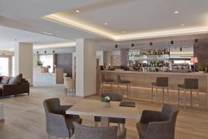 维哥迪法萨Design & Suite Hotel Ciarnadoi的大堂设有酒吧、桌子和椅子