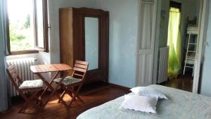 Casale Corte CerroB&B Al Mutpron的卧室配有一张床和一张桌子及椅子