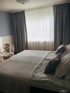 凯里迈基Lomatila Ollila Farm Stay的卧室配有带枕头的床铺和窗户。