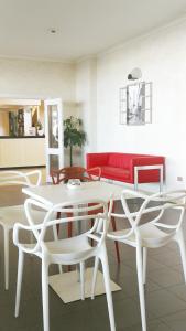 里米尼蒙马特酒店的客厅配有白色的桌子和椅子