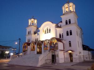 帕拉利亚卡泰里尼斯B&A Paralia的一座白色的大教堂,有两座塔楼和楼梯