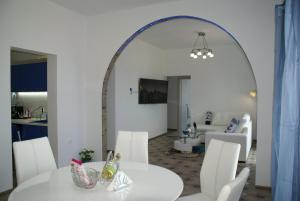 卡瓦拉Island Apartment的一间设有白色桌子和白色椅子的用餐室