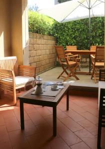 蓬塔阿拉Appartamenti Boboli的庭院配有桌椅和遮阳伞。