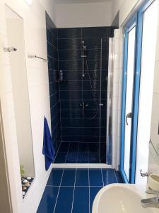卡瓦拉Island Apartment的浴室设有蓝色瓷砖淋浴。