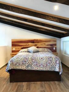 萨卡特兰Loft Don Silver的一间卧室配有一张大床和木制床头板