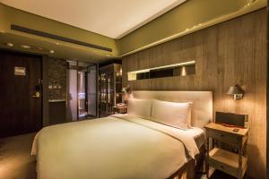 台北薆悦酒店的卧室配有一张白色大床和一张书桌