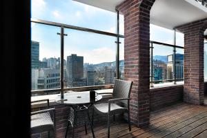 釜山阿尔班市酒店的市景阳台配有桌椅。
