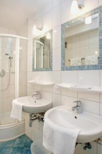 波恩莱茵兰德酒店的白色的浴室设有2个盥洗盆和淋浴。