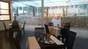 维斯Resort Village T.N. Milna的一间带桌椅和石墙的餐厅