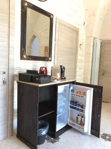 奥里亚Il Casolare Degli Ulivi的黑色柜台,配有冰箱和镜子