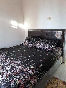 巴图Villa Puncak Garuda A5的一张床上的黑色床罩,上面有鲜花