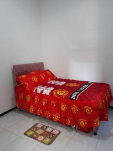 巴图Villa Puncak Garuda A5的一张铺有红色毯子的床和地板上的两张垫子