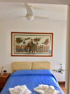 阿巴迪亚拉里亚纳La Meridiana sul Lago的卧室配有一张蓝色的床,墙上挂着一幅画