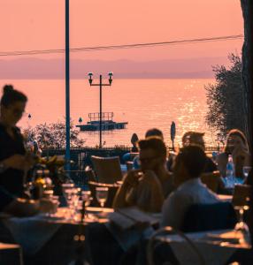 巴多利诺马克西米利安酒店的一群坐在桌子旁看海洋的人