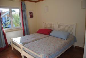 孔波尔塔孔波塔之家旅游度假村酒店的一间卧室配有一张带红色和蓝色枕头的床