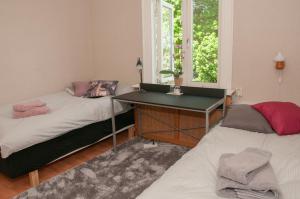 BroEkeby i Bro的配有书桌和窗户的客房内的两张床