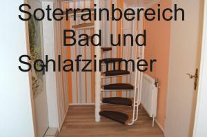 瓦尔内明德Twee Linden Warnemünde Zentrum的走廊上的一个螺旋楼梯,上面有“恶的单位”