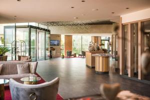 阿皮亚诺苏拉斯特拉达Weinegg Wellviva Resort的大厅配有沙发,大楼内设有一间酒吧