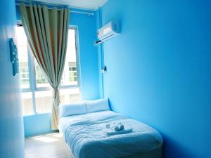诗巫CJ Home的蓝色的房间,窗户前设有一张床