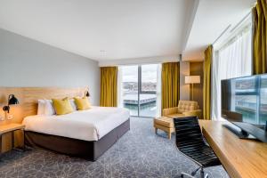 邓迪先瑞城市码头酒店&SPA的酒店客房设有一张床、一张书桌和一台电视机。