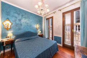 威尼斯潘特隆酒店的一间卧室设有一张床和蓝色的墙壁