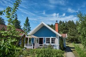 乌塞林Useriner Ferienhaus的一座带砖烟 ⁇ 的蓝色小房子