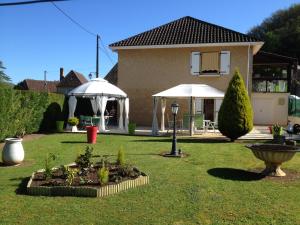 Cénac-et-Saint-JulienLa Touille的院子里有两把白色遮阳伞的房子