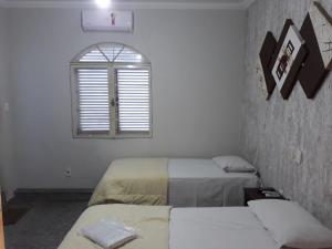 阿拉萨图巴阿拉卡酒店的客房设有两张床和窗户。