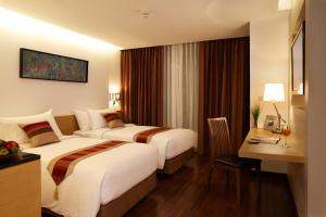 曼谷市角酒店的酒店客房配有两张床和一张书桌